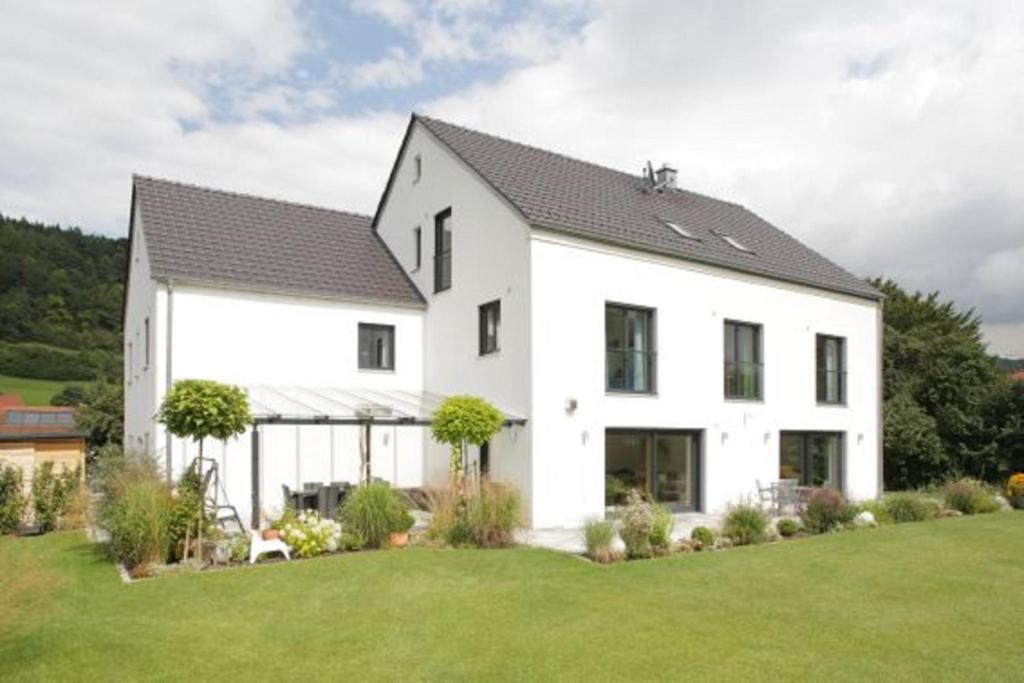 ein weißes Haus mit schwarzem Dach in der Unterkunft Gästehaus Lodermeier in Bad Abbach