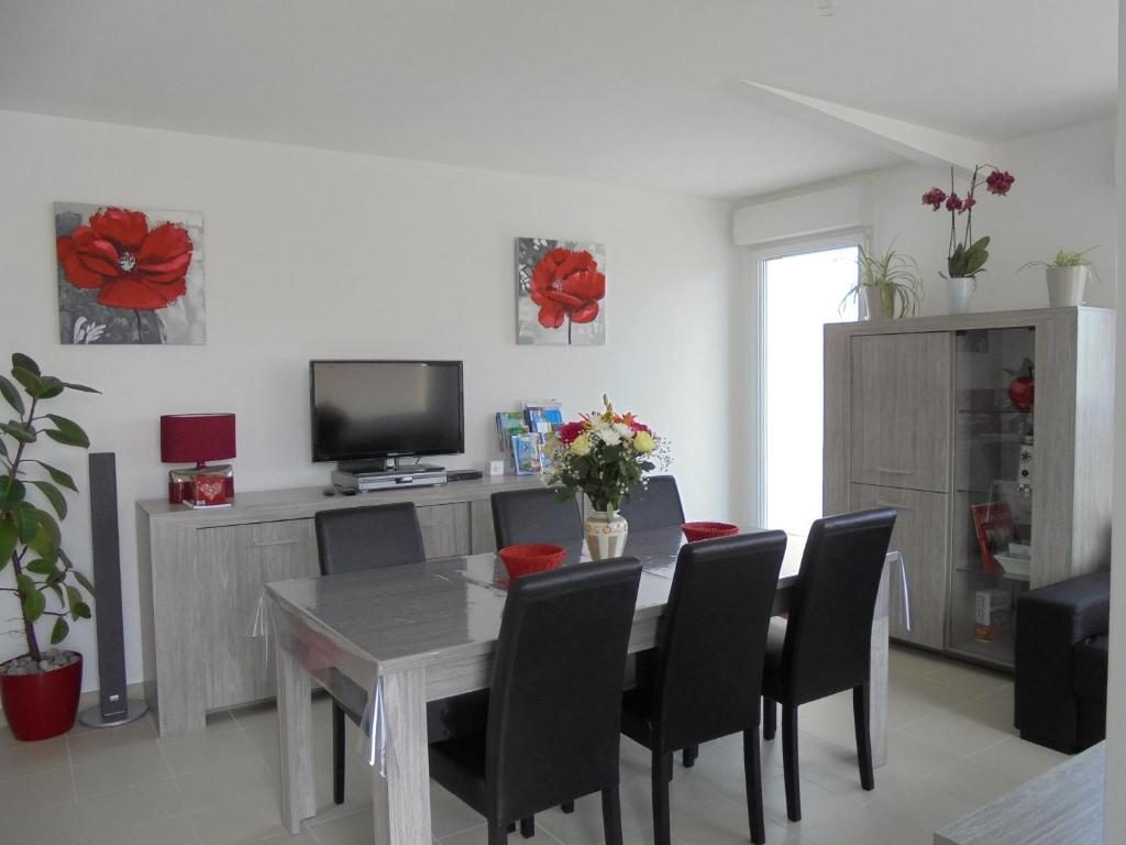 une salle à manger avec une table, des chaises et une télévision dans l'établissement Les Cygnes, à Criel-sur-Mer