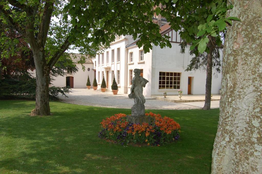 LudesにあるLa Villa Champagne Ployez-Jacquemartの花の咲く公園の中の像