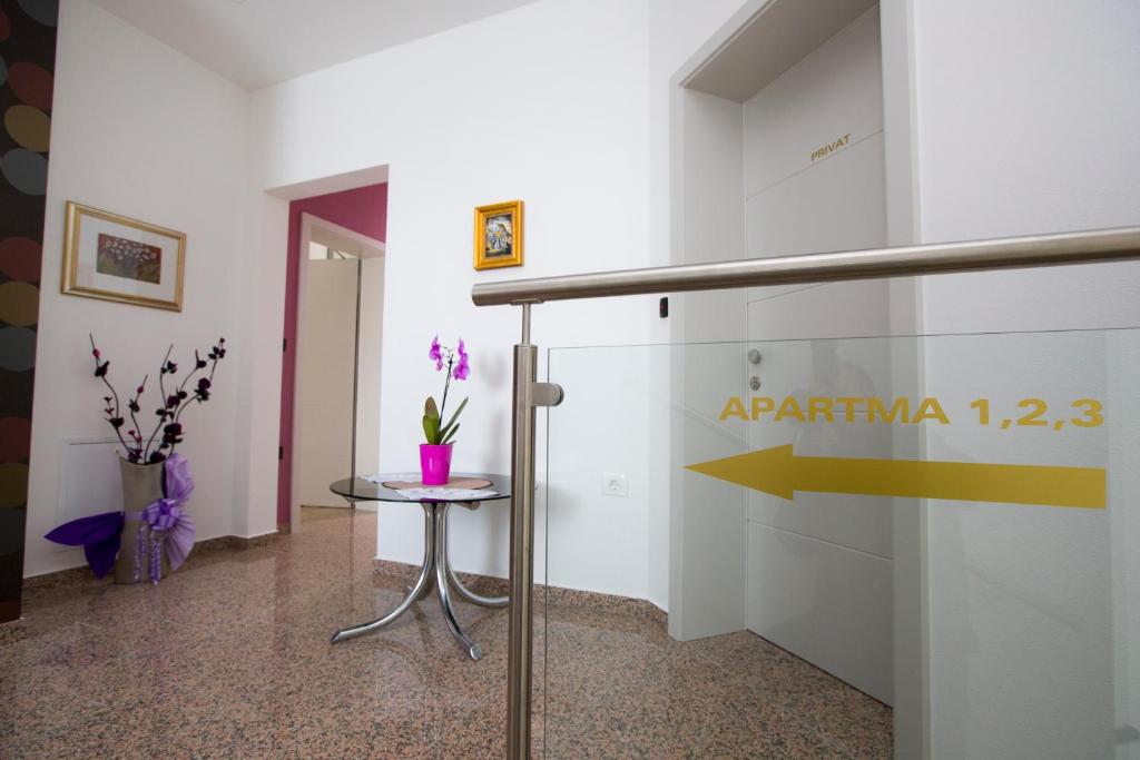 una habitación con una mesa y un cartel en la pared en Apartma Grže, en Postojna