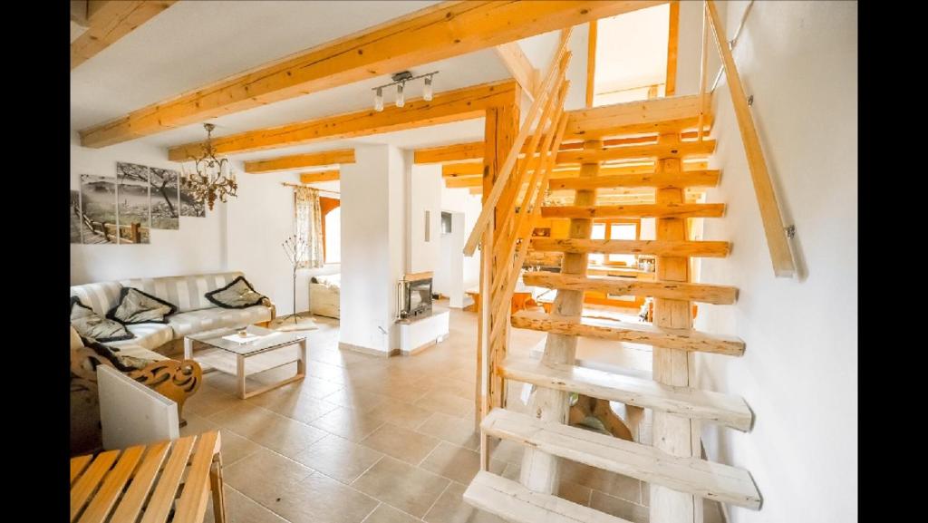 a living room with a wooden staircase in a house at Chata Paradise in Smižany