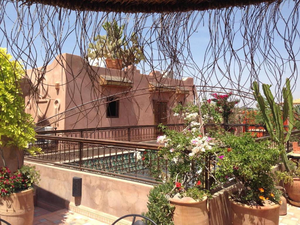 a building with pots of flowers on a balcony at Riad Mehdia in Marrakesh