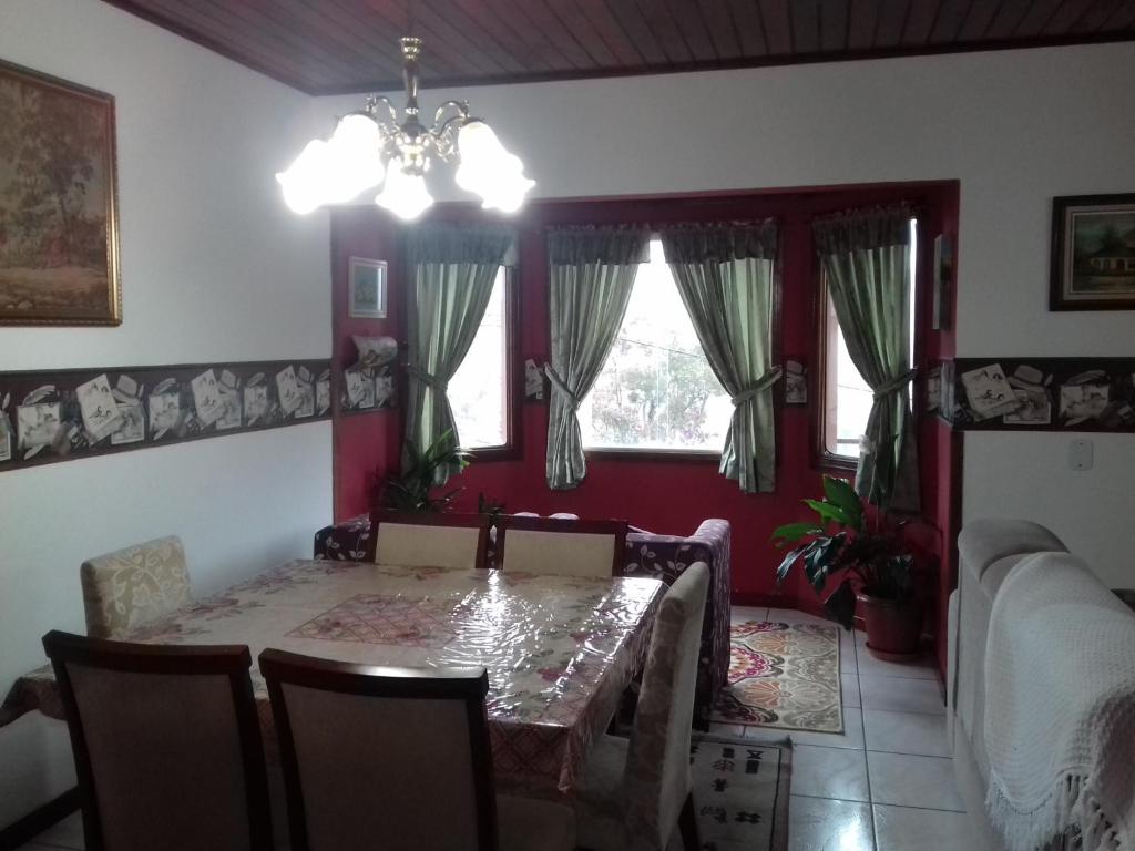 ein Esszimmer mit einem Tisch mit Stühlen und einem Kronleuchter in der Unterkunft Casa Da Severina in Campos do Jordão