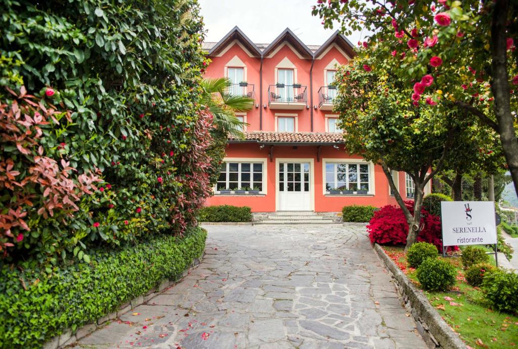 une maison rose avec un panneau devant elle dans l'établissement Hotel Serenella, à Baveno