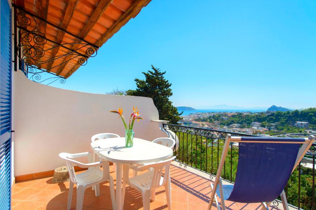 a table and chairs on a balcony with a view at Villa Angela Apartment in Ischia Town