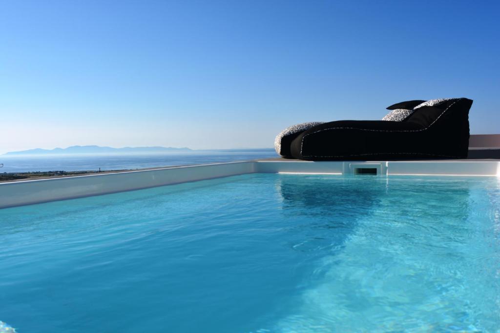 a large black suit case sitting on top of a swimming pool at Elysian Santorini in Oia