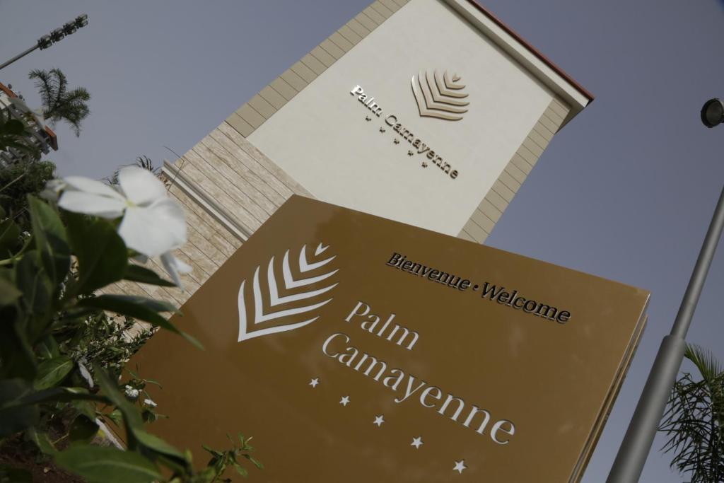 a sign in front of a building at Palm Camayenne in Conakry