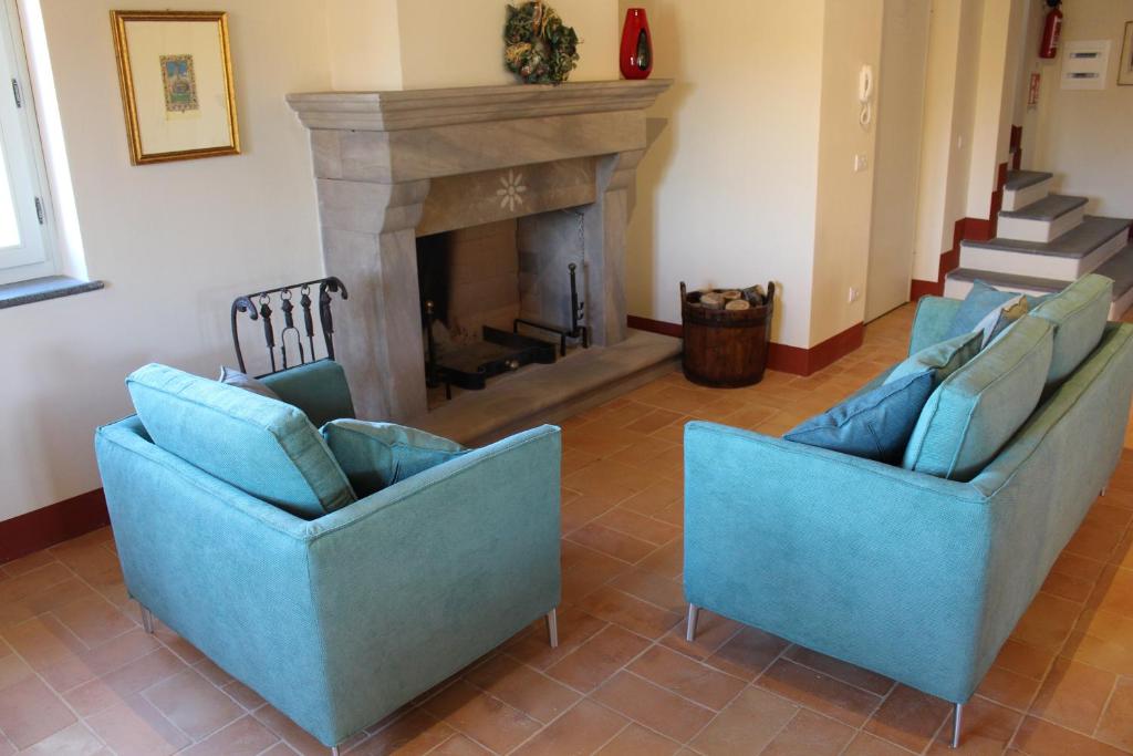 AcquaspartaにあるIl poggio del tartufoのリビングルーム(青い椅子2脚、暖炉付)