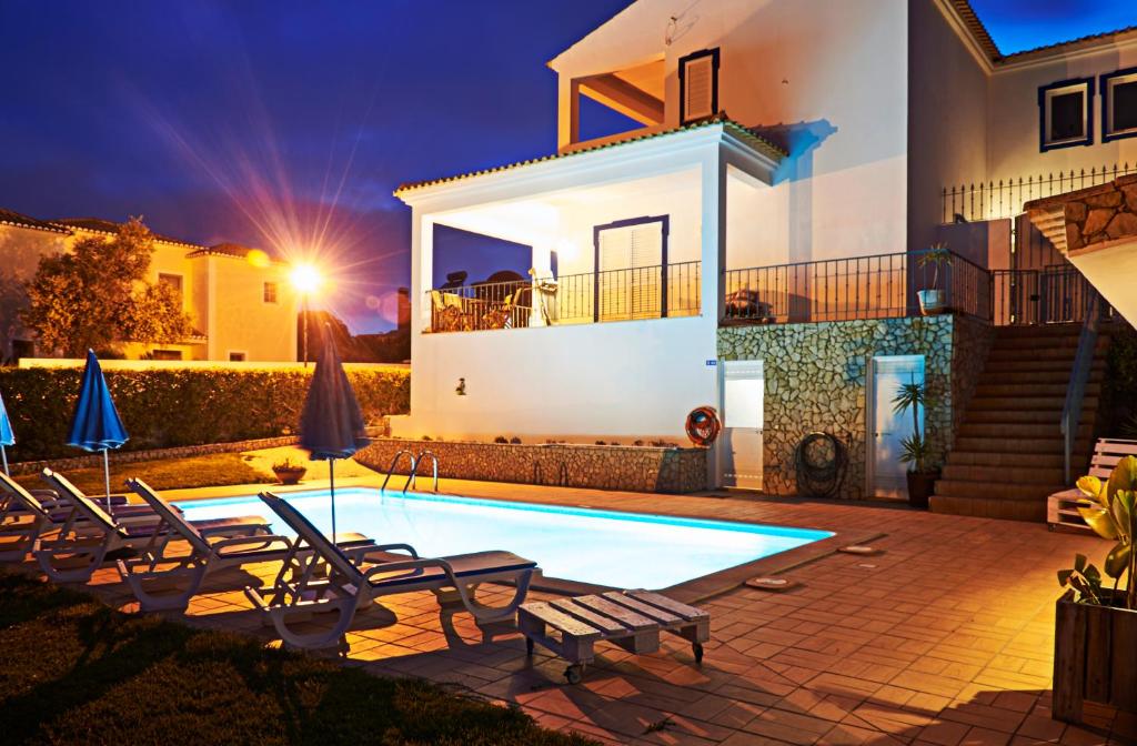 a villa with a swimming pool at night at Villa Solarium in Carvoeiro