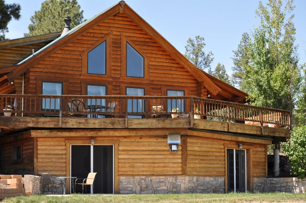 a log home with a deck and patio at Elkwood Manor Bed & Breakfast in Pagosa Springs