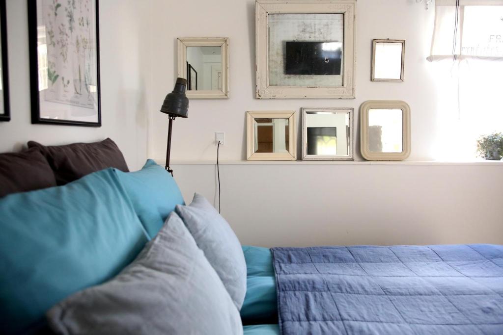 a living room with a blue couch and some mirrors at Dragondrum Bed & Kitchen in Ullerslev
