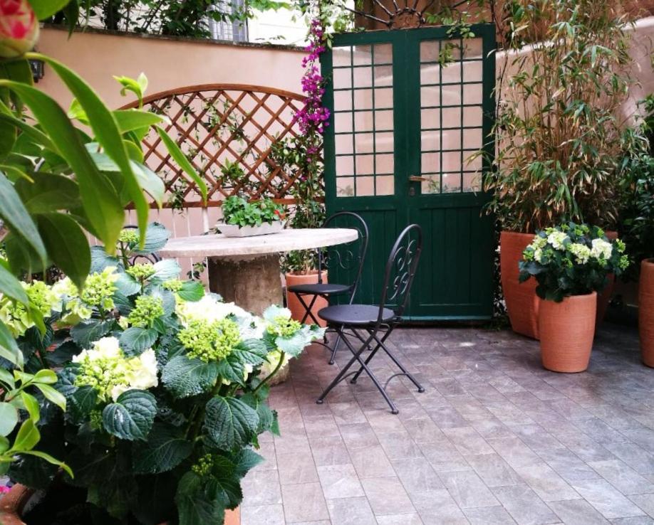 a patio with a table and chairs and plants at La Piazzetta delle Regine in Rome