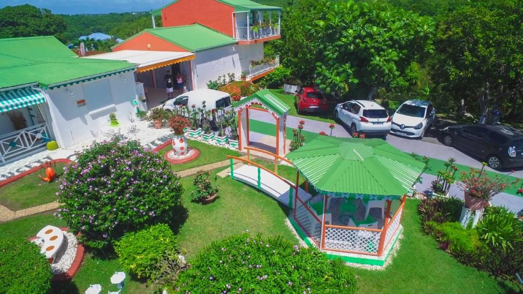 una casa de juguete con parque infantil en un patio en Villa Ludivine, en Sainte-Anne