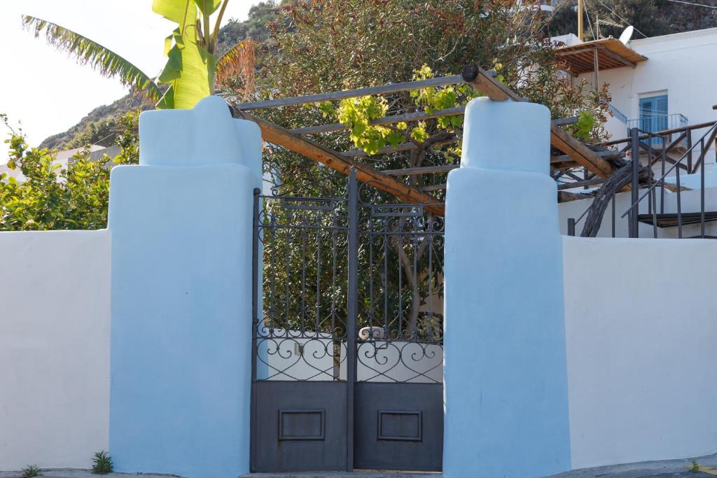 a white fence with a black gate with a plant at La Casa del Pescatore in Filicudi