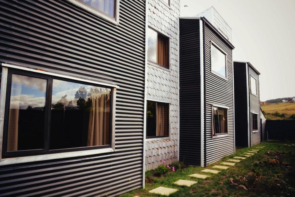 una casa con revestimiento en blanco y negro en HelChiloé Aparthotel en Castro