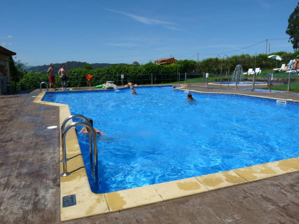 a large swimming pool with people in the water at Camping Colombres in Colombres