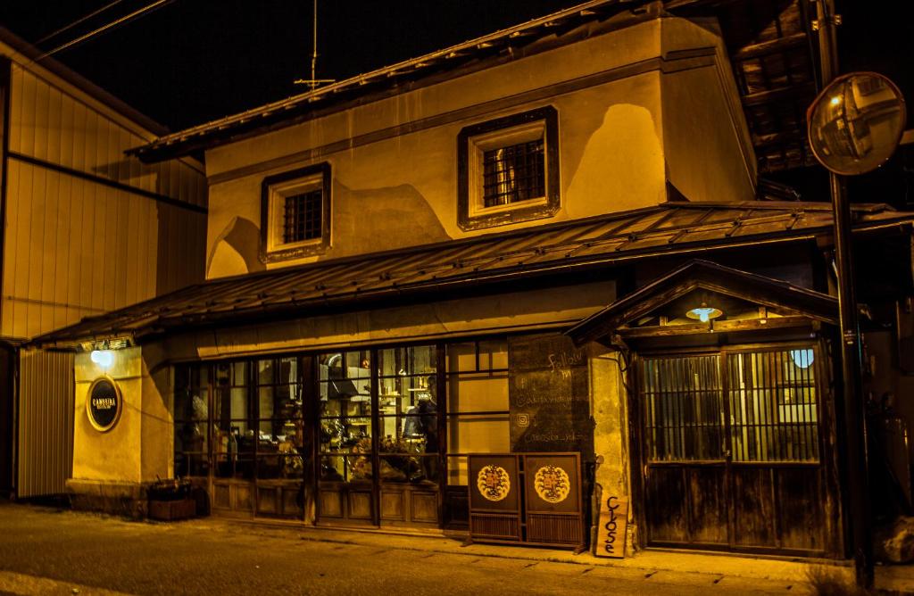 un edificio con un negozio di fronte alla notte di Hostel&Bar CAMOSIBA a Yokote