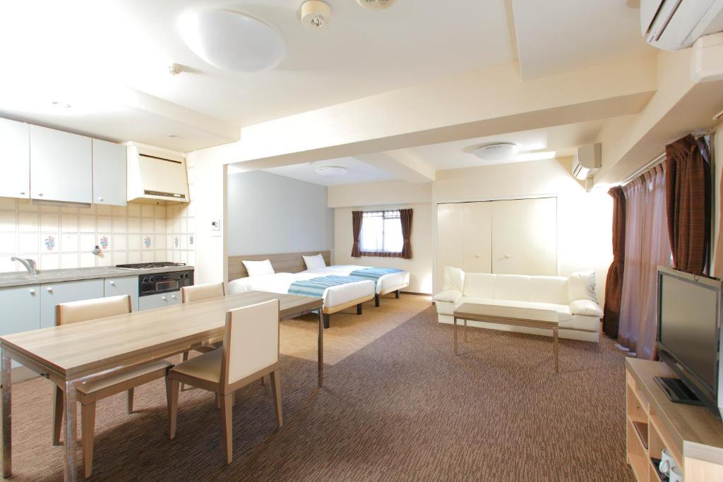 a living room with a kitchen and a dining room at HOTEL MYSTAYS Otemae in Osaka