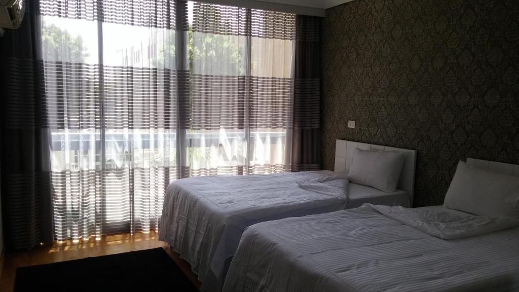 a hotel room with two beds and a window at Khayatz Apartment in Cairo