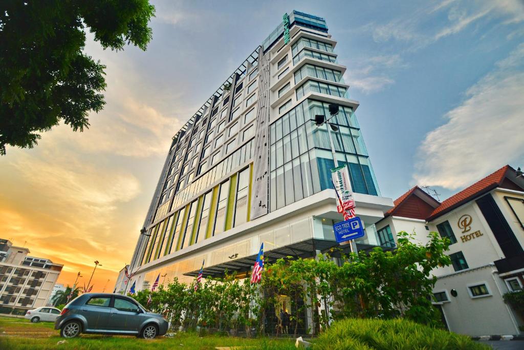 ein vor einem Gebäude geparkt in der Unterkunft Eco Tree Hotel, Melaka in Malakka