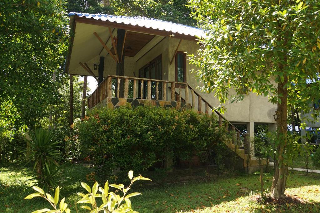 a house with a balcony on the side of it at Wonderland Healing Center in Thongsala