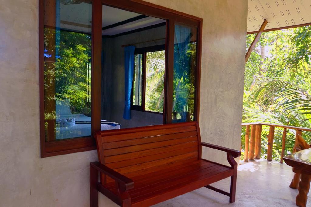 a wooden bench in a room with a mirror at Wonderland Healing Center in Thongsala