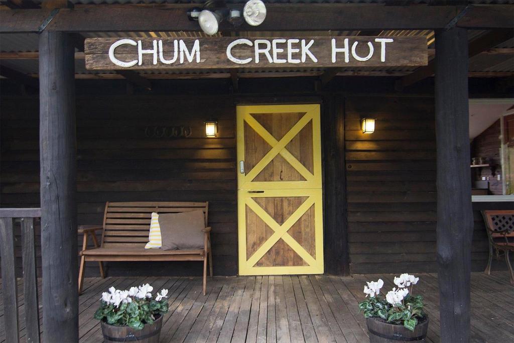 a building with a yellow door and a sign that reads chim creek hut at Chum Creek Hut in Chum Creek