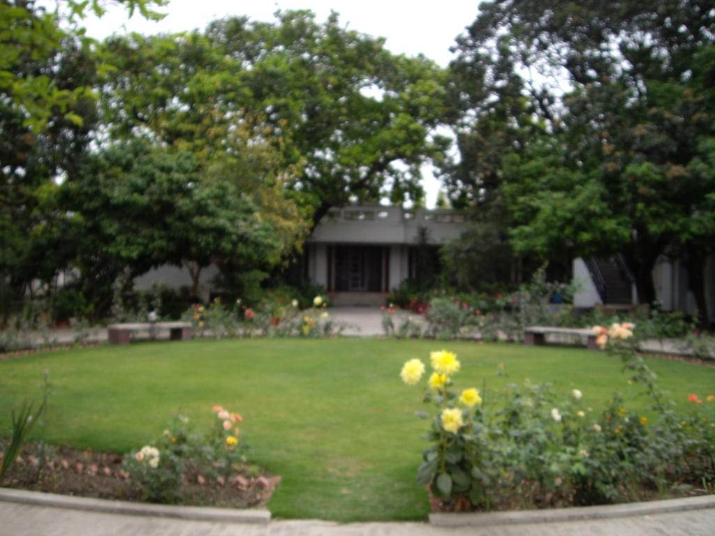 a garden with flowers and benches in a yard at Vatika Homestay in Varanasi