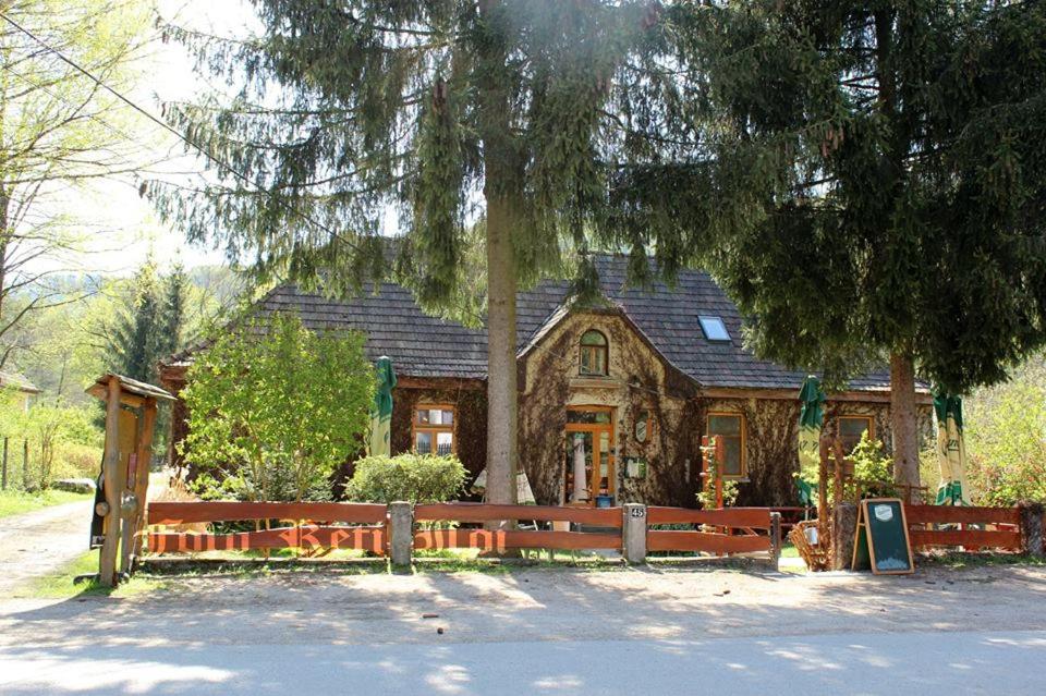 a house with a fence in front of it at Vadszőlő Szálló és Étterem Bakonybél in Bakonybél