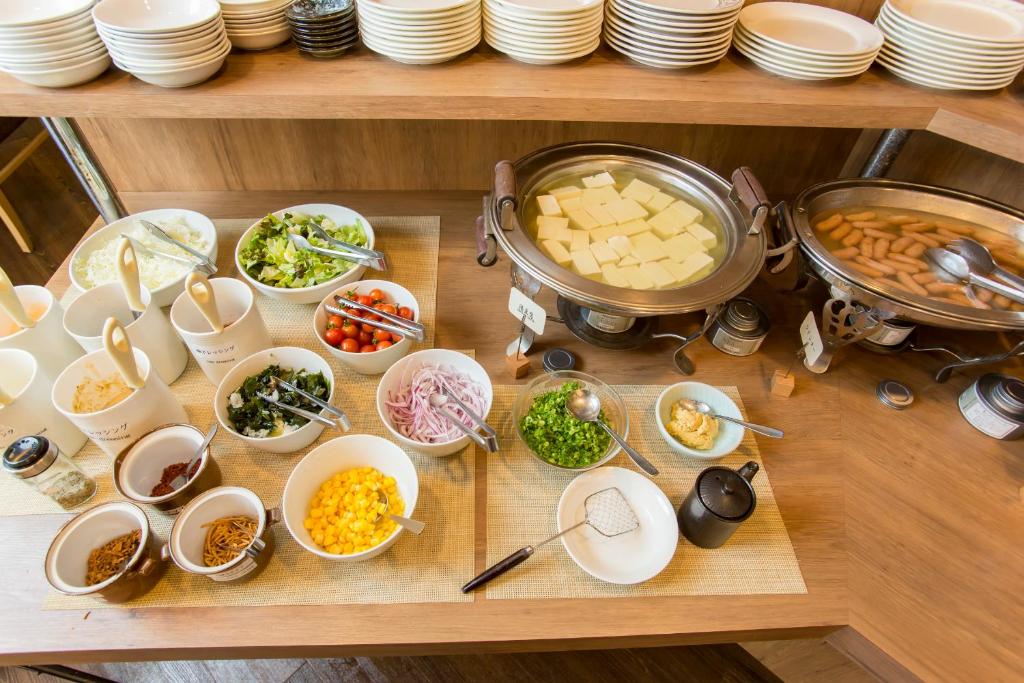 a table filled with bowls and plates of food at Hotel Route-Inn Tokyo Ikebukuro in Tokyo