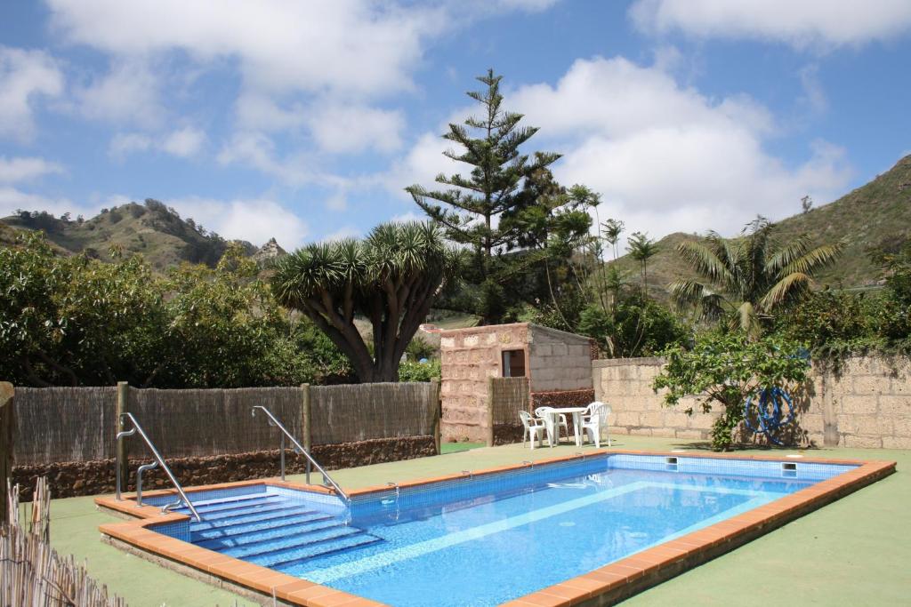 einen Pool in einem Garten mit einem Zaun und Bäumen in der Unterkunft Finca El Vergel Rural in Tegueste