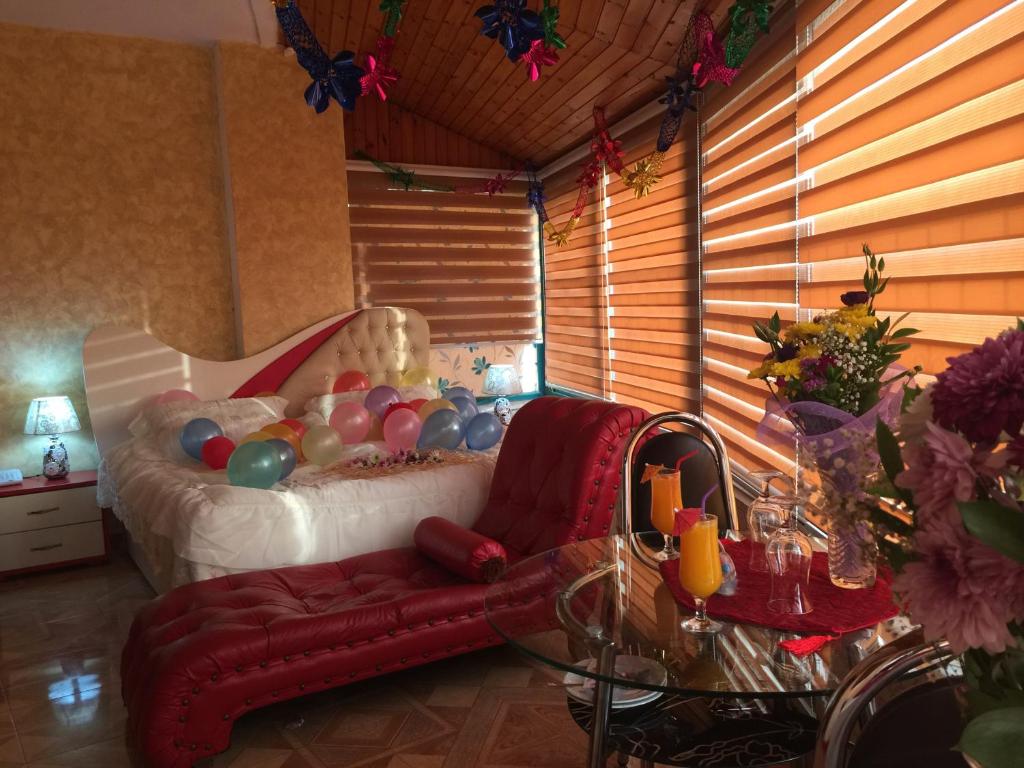 a bedroom with a bed with a red couch and a glass table at Isra Hotel in Nablus