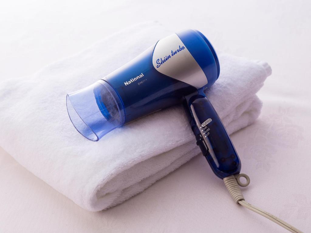 a blue blow dryer sitting on top of a towel at Hotel Route-Inn Tokyo Ikebukuro in Tokyo