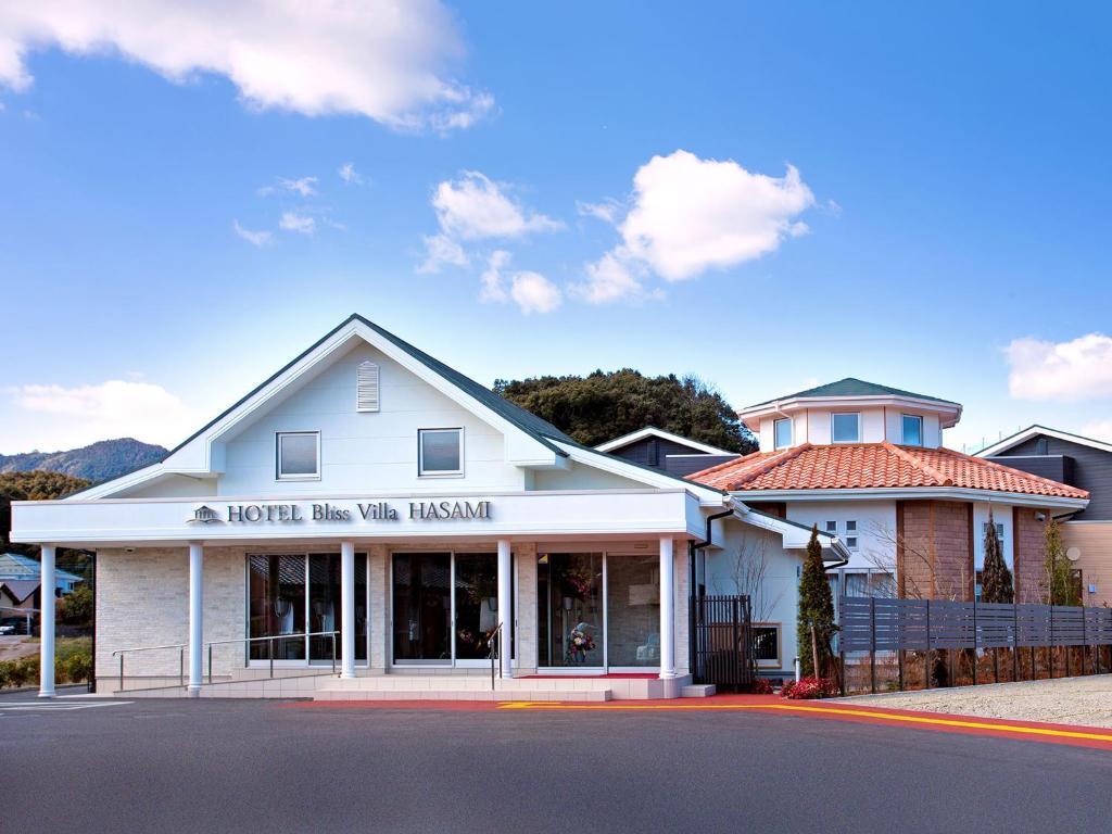 a white building with a sign on the front of it at Hotel Bliss Villa Hasami in Hasami