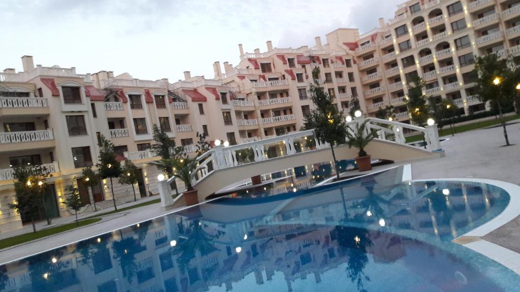 a large swimming pool in front of a large building at East from Paradise Apartment in Varna City