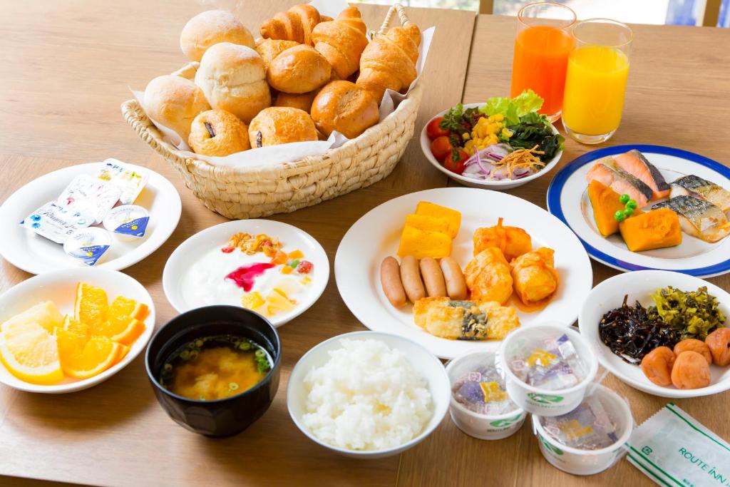a table with plates of food and bowls of food at Hotel Route-Inn Tokyo Ikebukuro in Tokyo
