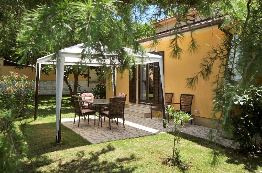 d'une terrasse avec une table et des chaises sous un kiosque. dans l'établissement Holiday Home Maya, à Medulin