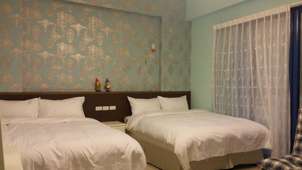 台東市的住宿－台東愛琴海民宿-寶莉館，一间卧室设有两张床和壁纸墙