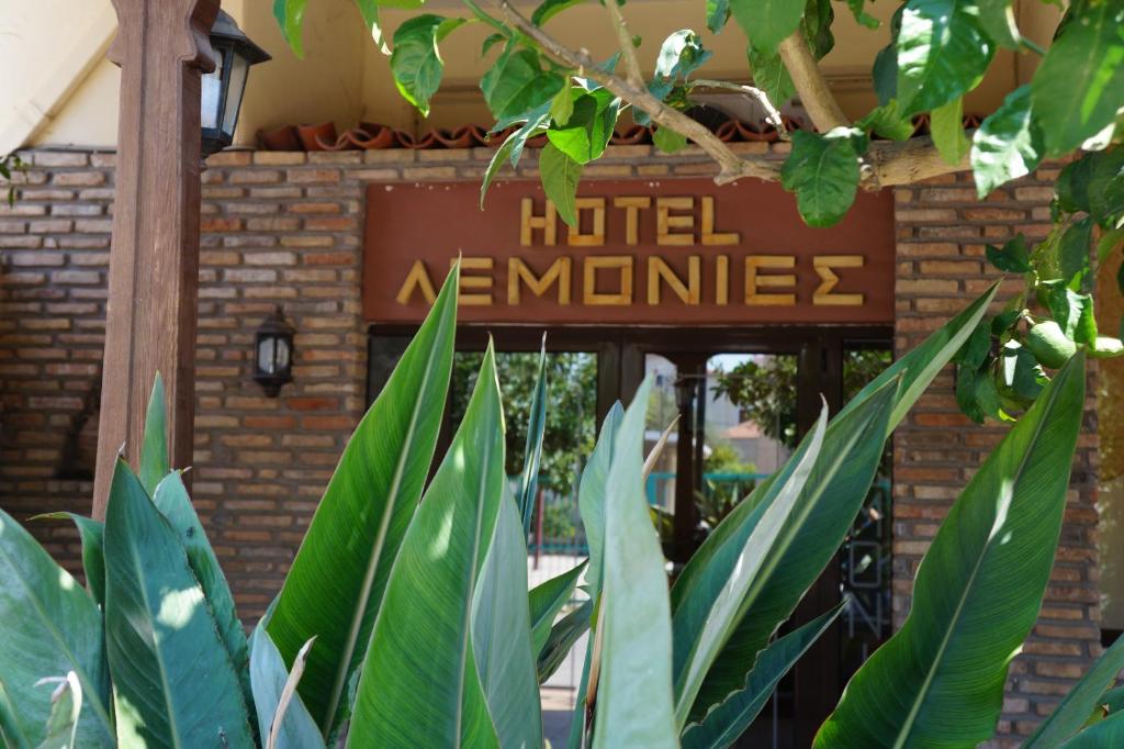 a sign for a hotel entrance with green plants at Lemonies in Diakopto