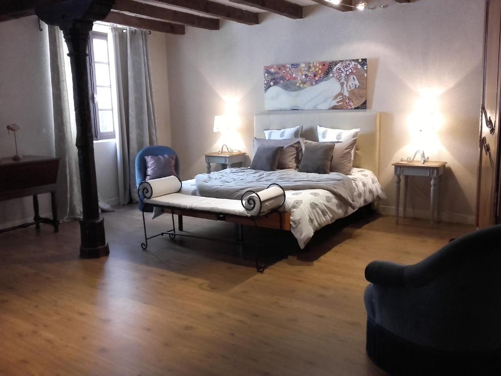 a bedroom with a bed with two tables and two lamps at La Maison Rouge in Chinon