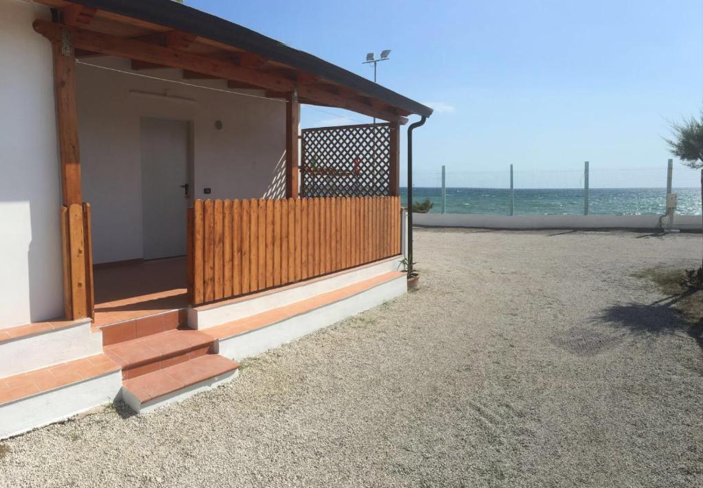 ein Gebäude mit einer Veranda mit Meerblick im Hintergrund in der Unterkunft Camping Lido di Salerno in Pontecagnano