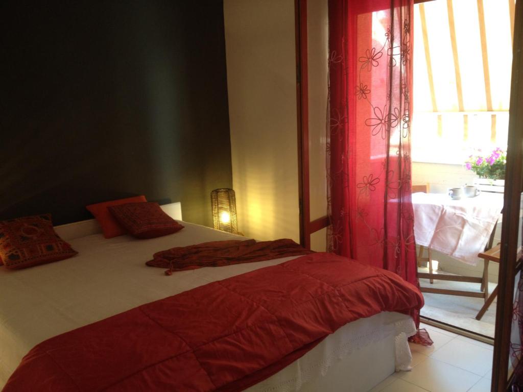 a bedroom with a bed with red sheets and a window at Casa Dellestate in Grottammare