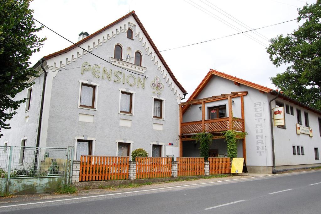 Ein weißes Gebäude mit einem Zaun davor. in der Unterkunft Pension U Dubu in Franzensbad