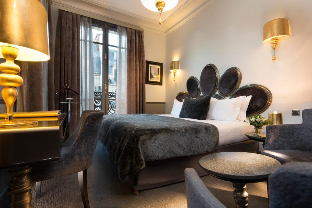 パリにあるホテル ルーメン パリ ルーヴルの大きなヘッドボード付きのベッドが備わるホテルルームです。