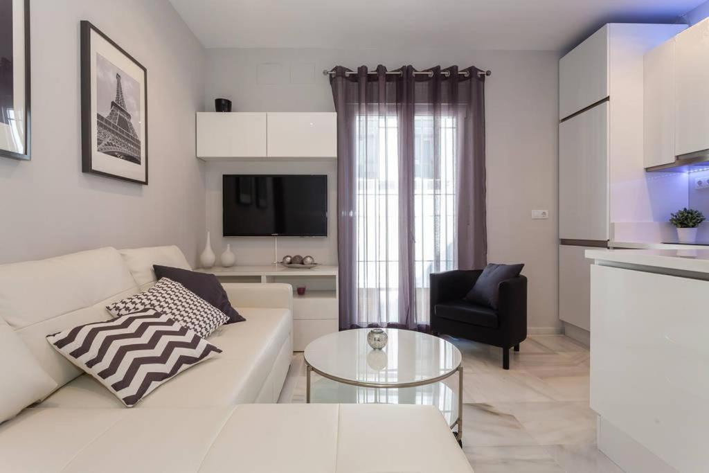 a living room with a white couch and a table at Apartamento Castillo San Marcos in El Puerto de Santa María