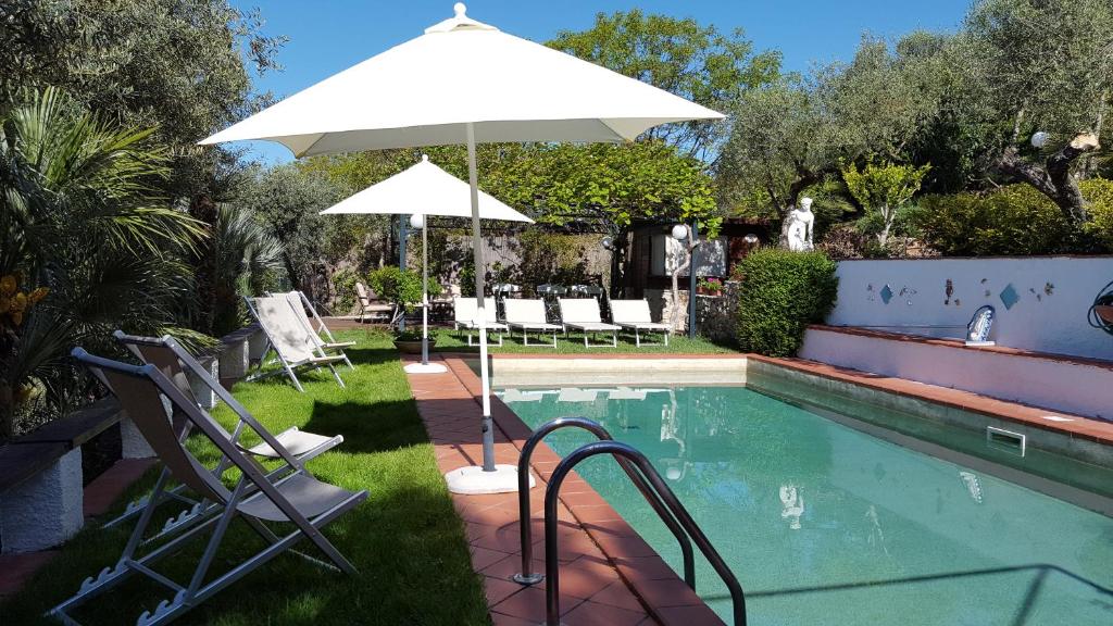 an umbrella and chairs next to a swimming pool at La Maison Galu' in Itri