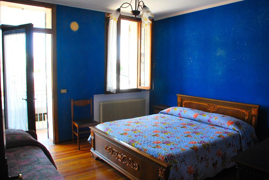 una camera con pareti blu e un letto in una stanza di Casa Vacanze Vedelago a Istrana
