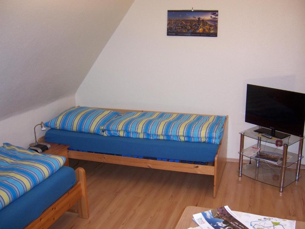 sala de estar con sofá azul y TV en Haus am Roseneck, en Lüneburg