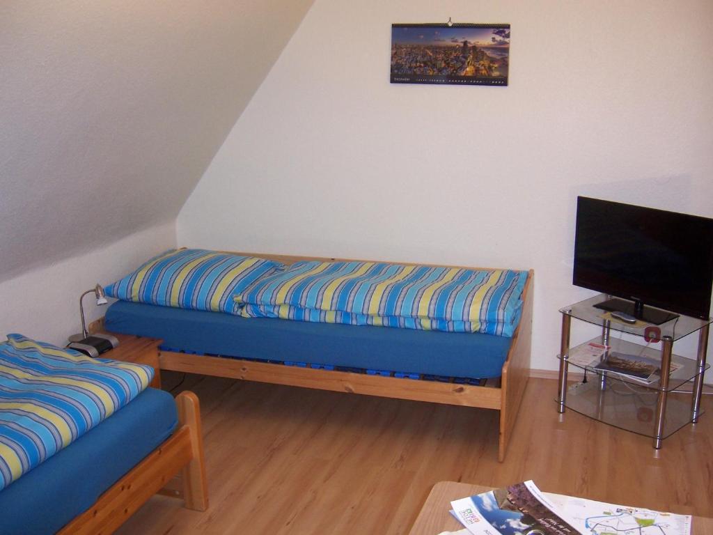 a living room with a blue couch and a tv at Haus am Roseneck in Lüneburg