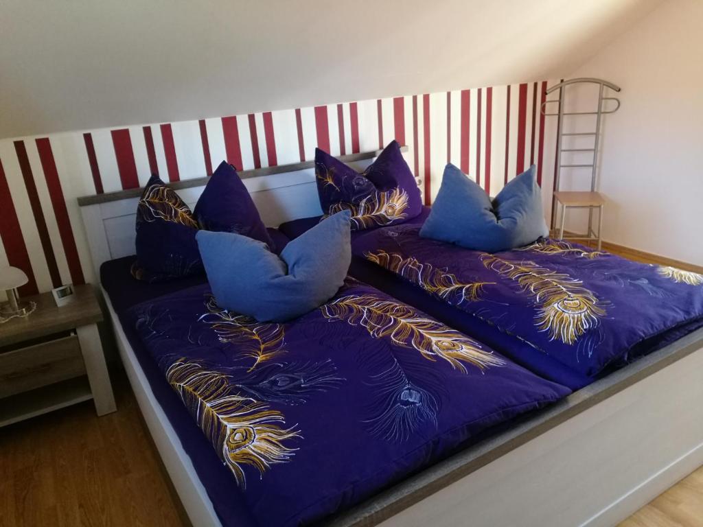 a bed with blue pillows on top of it at Ferienhaus am Radweg in Brotterode